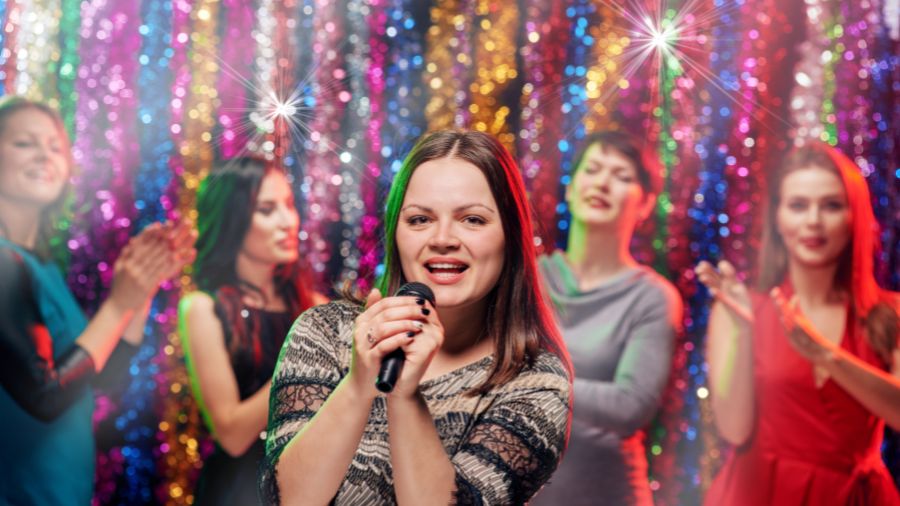 En person synger karaoke på en firmafest i forbindelse med en aktivitet til firmafest.