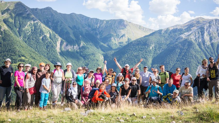 Her udføres en teambuilding-aktivitet, hvor en gruppe af mennesker er samlet i Harzen, og man ser bjergene i baggrunden af billedet.