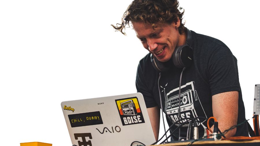 En person står på scenen som DJ og laver underholdning til firmafesten.