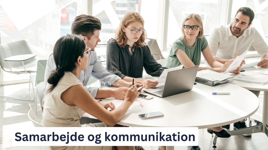 Billedet viser en gruppe medarbejdere, der sidder omkring et bord og engagerer sig i en diskussion. De har bærbare computere, dokumenter og smartphones foran sig, hvilket indikerer et møde, hvor samarbejde og kommunikation er i fokus. Nederst på billedet står teksten: "Samarbejde og kommunikation."