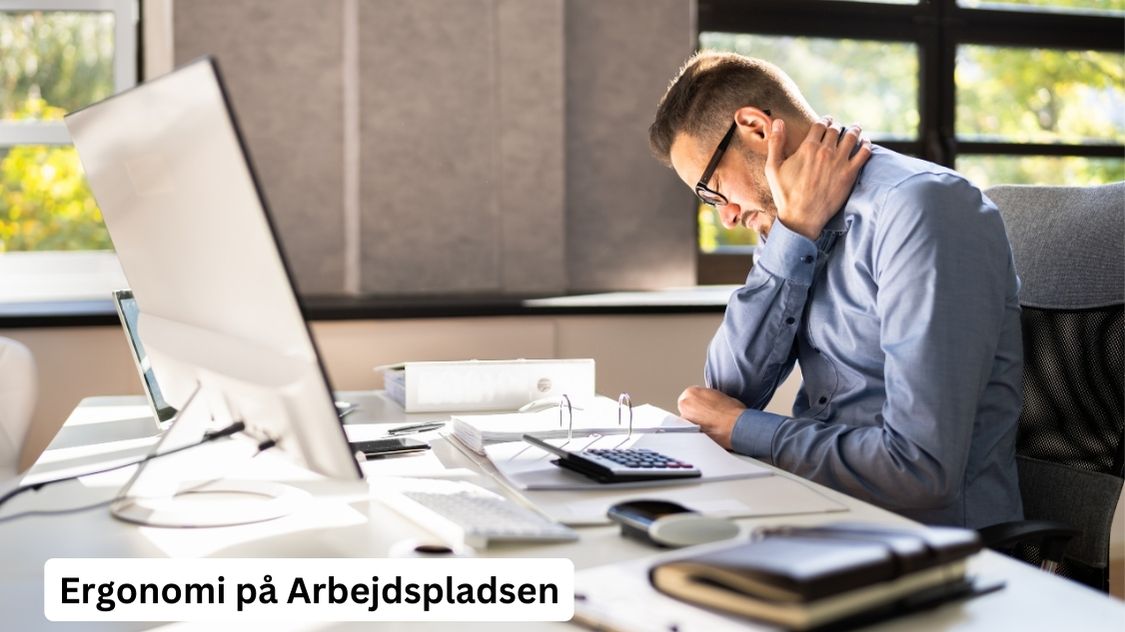 Billedet viser en mand, der sidder ved et skrivebord og ser ud til at have nakkesmerter. Han holder sin nakke med den ene hånd, mens han arbejder ved computeren. Teksten "Ergonomi på Arbejdspladsen" er synlig i nederste venstre hjørne af billedet. Dette billede illustrerer vigtigheden af god ergonomi på arbejdspladsen for at undgå arbejdsrelaterede skader og forbedre medarbejdernes velbefindende.