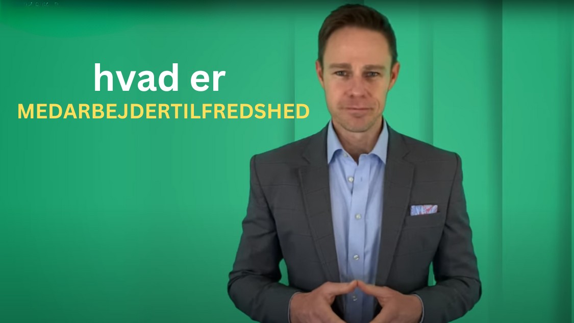 Billedet viser en mand i jakkesæt, der står foran en grøn baggrund. Teksten "hvad er MEDARBEJDERTILFREDSHED" står tydeligt ved siden af ham. Dette billede er sandsynligvis brugt til at introducere eller forklare begrebet medarbejdertilfredshed, hvilket er et vigtigt emne inden for arbejdspladskultur og HR-praksis.